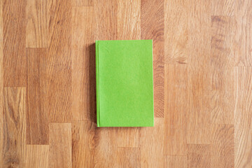Grünes Buch Flatlay auf Holztextur