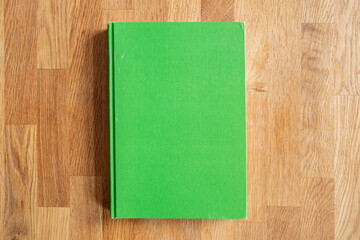 Grünes Buch Flatlay auf Holztextur