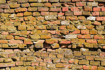 Rough textured surface of an old curved brickwork wall. Background or graphic resource