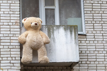 Teddy bear dries on the balcony of the house after washing.