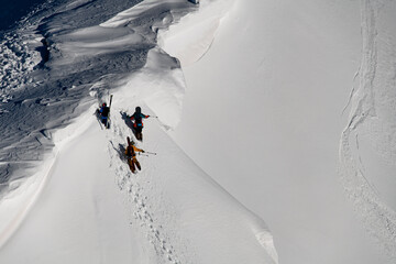 aerial view of group of freeriders climbing to the top of snowy slope