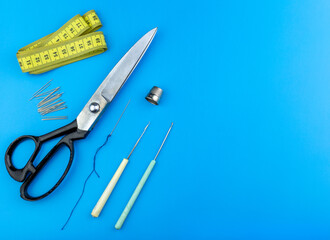 Tailor's set of tools for sewing lies on a blue background. Copy space.	