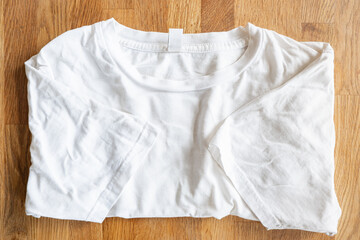 weißes T-Shirt Flatlay auf Holztextur