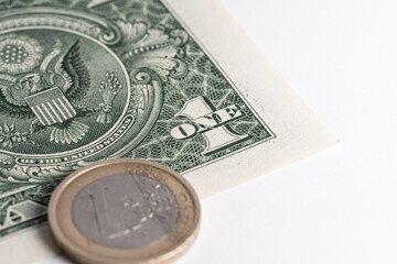 One dollar banknote and one euro coin on white background. International payments and exchange rate comparison.