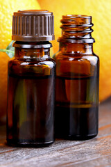 Natural organic Orange essential oil in a glass bottle.Fresh Orange fruits with green leaves. Healthy vegan food. Vitamins food.Ripe oranges.Selected focus.Vertical orientation