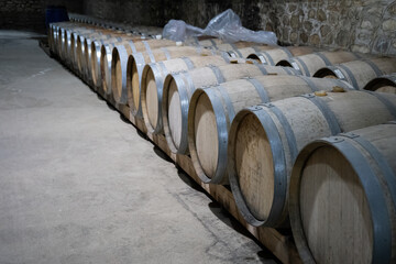 Wine barrels stacked in the old cellar of the winery.