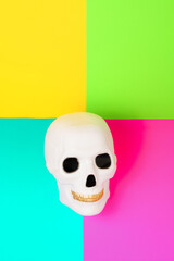 Minimal composition of golden teeth skull on background with vivid colours.
