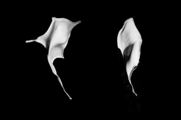 White paint splash isolated on black background.