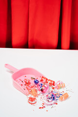 Creative concept with red curtain,pink dustpan  and streamers . Minimal New Year background idea.