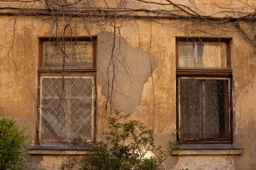 An architectural element of old building facade of typical houses in Odessa old town city center. Huge vintage windows, dirty scratched walls