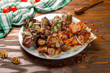 platter of different kebabs on wooden table