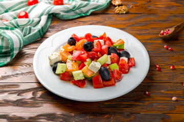 Greek salad with feta on wooden table