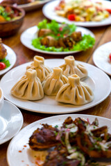 Georgian cuisine foodset from khachapuri, khinkali, pkhali, dolma, satsivi side viev on wooden table vertical