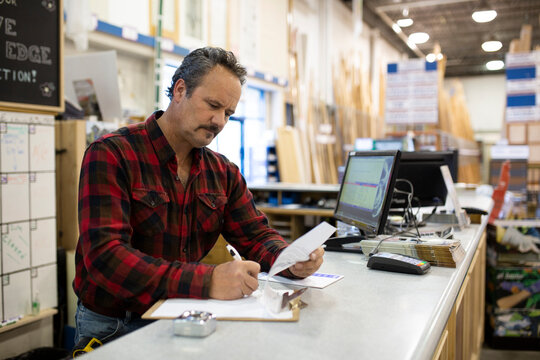 Portrait Of Smiling Worker At Counter In Home Improvement Store