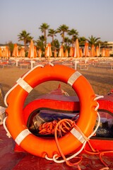 lifebuoy and sunbeds at empty sandy castello beach during sunrise at Vieste, Gargano, Apulia, Italy