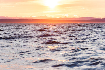 Obraz premium Light hits choppy ocean waves at sunset