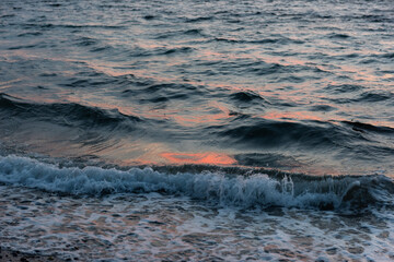 Light hits choppy ocean waves at sunset