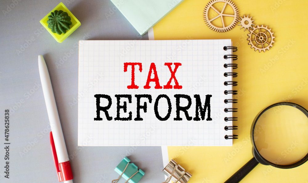 Poster tax reforms. man holding a card with a message text written on it