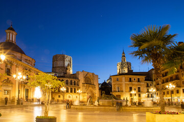 Fototapeta premium VALENCIA , SPAIN - DECEMBER 6, 2021: Square of Saint Mary's with Valencia Cathedral Temple, Basilica de la nuestra senora de los desamparados and the rio tura fountain in old town.