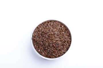 Flax seeds in a white ceramic cup on a white background.