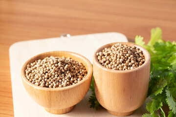 Coriander seeds in a wooden cup copy space