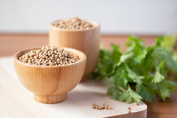 Coriander seeds in a wooden cup copy space