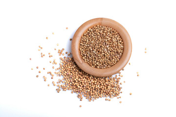 coriander seeds in a wooden cup on a white background