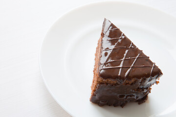 A piece of chocolate cake is on a white plate. Close-up cake. - 478627695