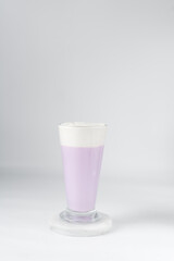 Glass of purple latte with whipped cream, Glass of ube latte