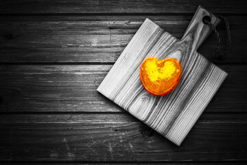 Golden heart shaped potato stylished as burning heart on a cutting board placed on a  wooden...