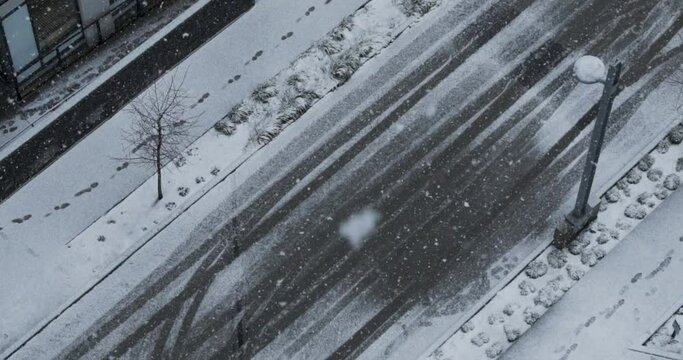 Top-down view of a snowy road and street lights during a snowfall in Vancouver, Canada