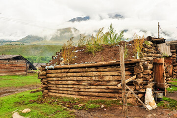 Mountain village, wooden houses, mountains, forests, natural scenery, under the background of cloudy weather. In Altay, Xinjiang, China.