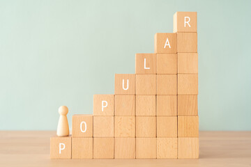 「POPULAR」と書かれた積み木と人形