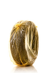 Car tire in yellow bag for storage. One winter tyre isolated on white background..