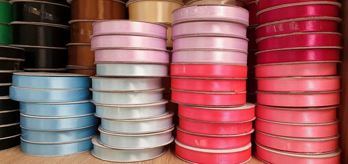 Bright ribbons for decoration and gift wrapping. Many spools of colored ribbons. Beautiful ribbons on the shelf in the store.