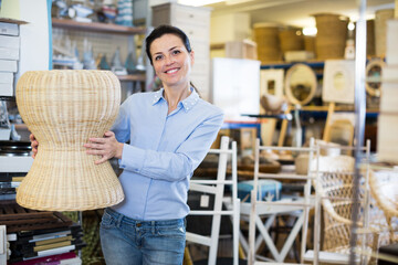 Woman holding chair before buying at the modern interior shop