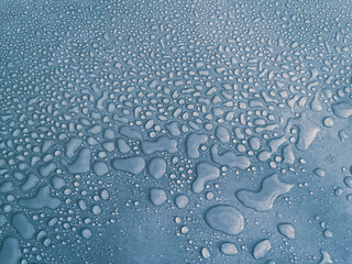 water drops of different sizes on a blue surface, drops texture, rain on blue tile, rain texture, refreshing background, hrizontal
