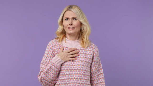 Elderly blonde woman lady 40s years old wears warm shirt look camera pointing fingers herself ask say who me no thanks i do not need it isolated on plain pastel light purple background studio portrait