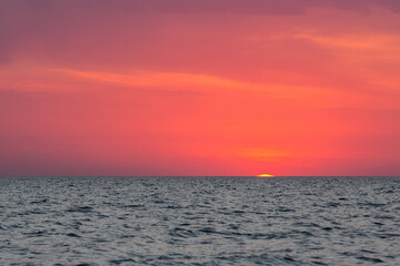 The sun peeked over the horizon at dawn. Dawn over the sea.