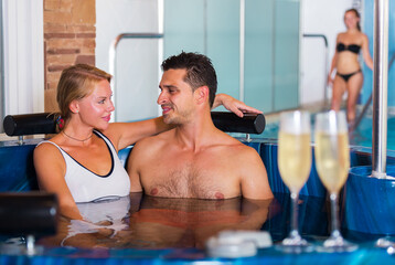Loving couple talking while relaxing together in spa center