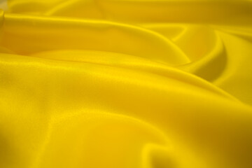 Abstract Gold Satin Silky Cloth Fabric Textile Drape with Crease Wavy Folds background.With soft...