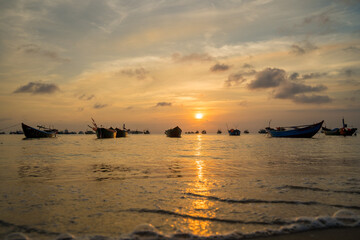 Tropical Seascape with a boat on sandy beach at cloudy sunrise or sunset. Beautiful sunset tropical beach with small boat and pink sky for travel and vacation in holiday relax time. Vung tau city.