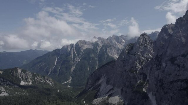 Video of a drone with a descriptive plane with recoil over the Vrsc pass in Slovenia with mountains on the horizon.