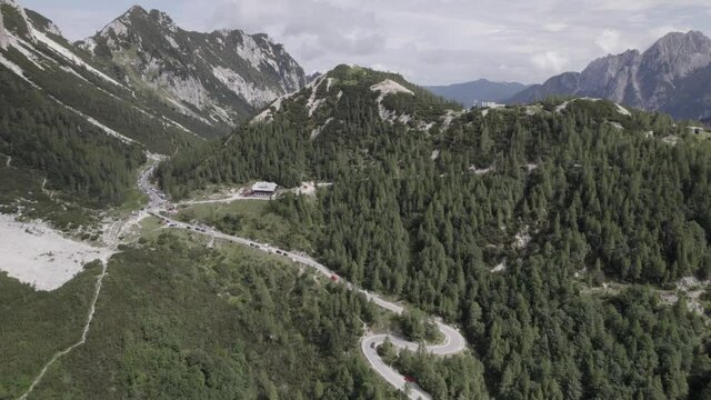 Drone video with descriptive frontal shot over the Vrsc pass in Slovenia with mountains on the horizon.