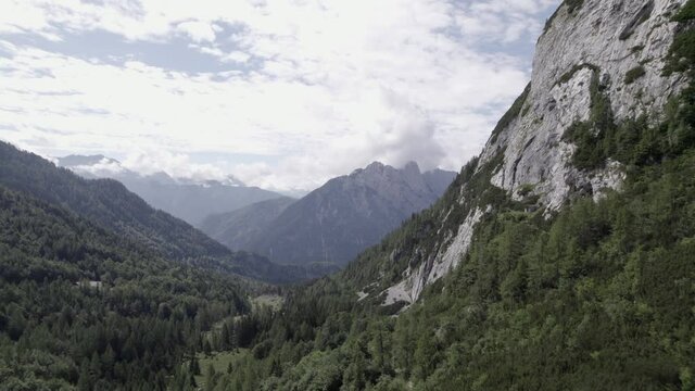 Drone video with descriptive frontal shot over the Vrsc pass in Slovenia with mountains on the horizon.