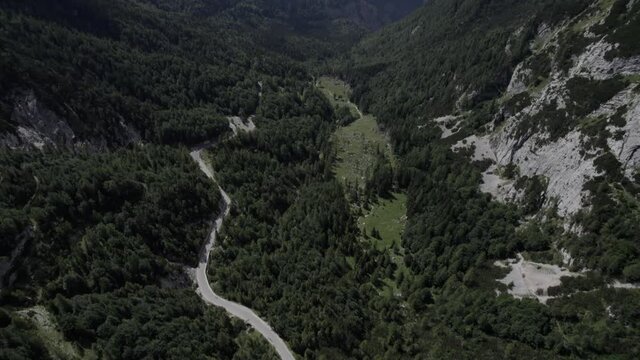 Drone video with descriptive frontal shot over the Vrsc pass in Slovenia with mountains on the horizon.