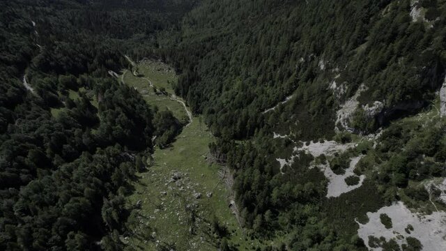 Video of a drone with a descriptive plane with recoil over the Vrsc pass in Slovenia with mountains on the horizon.