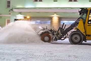 Snow removal equipment. Snowplow on road at night, cleaning city street from snowdrift after heavy...