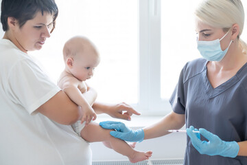 The doctor makes a baby vaccination on a white background.