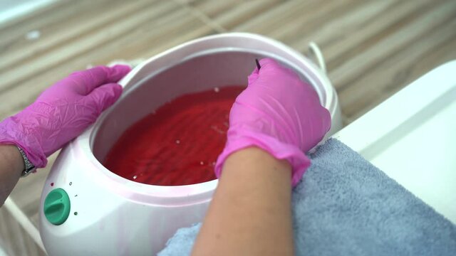 Beautiful Asian young woman having a paraffin foots and hands spa at beauty - spa shop. Foot and hand paraffin treatment.